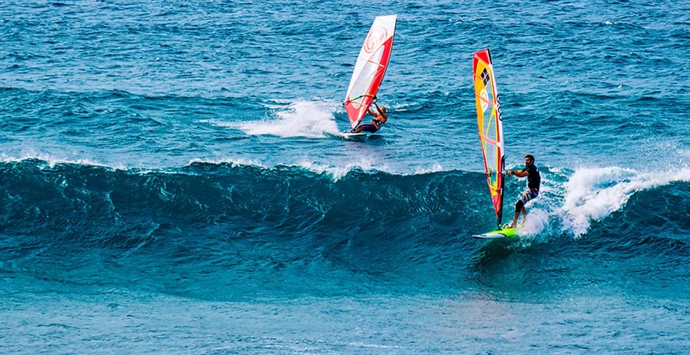 Windsurfers riding waves at Hoʻokipa Beach Park on Maui’s north shore