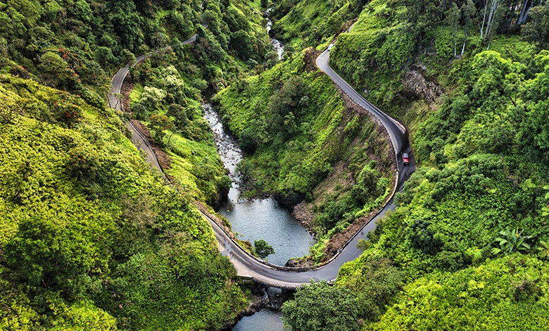 Scenic coastal view along the Road to Hana in Maui with lush green cliffs and turquoise ocean