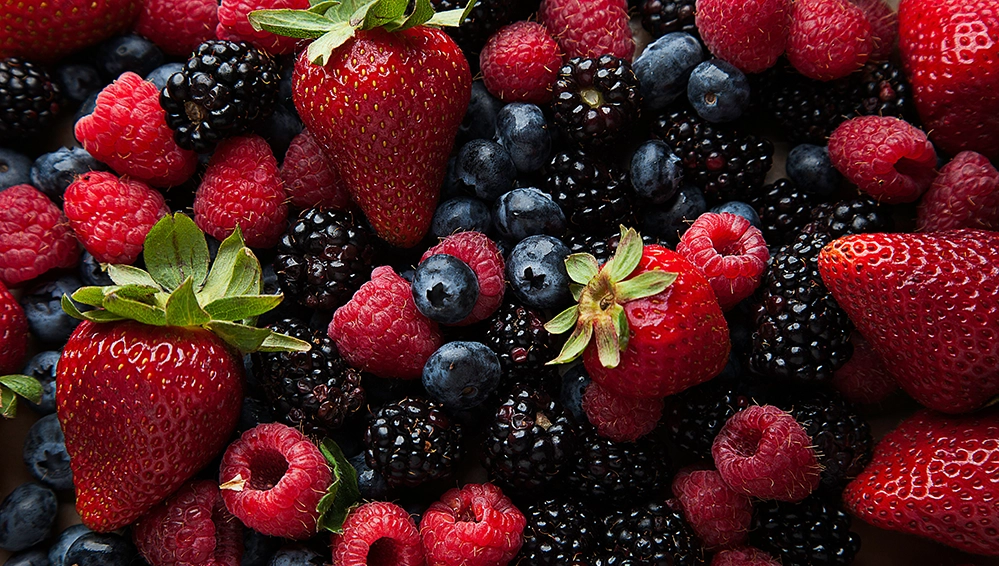 A Berry Good Breakfast Smoothie — Food for Thought 4 Overhead close-up of fresh mixed berries including strawberries, raspberries, blackberries, and blueberries.