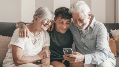 Grandparents Raising Grandchildren 1 Grandparents helping grandchild with homework at the kitchen table, symbolizing intergenerational caregiving and learning.