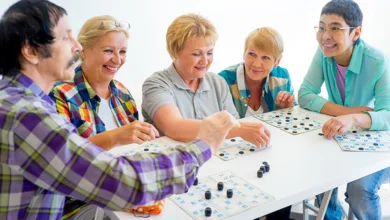 Why Bingo Is Great for Your Health After 50 6 Older adults gathered around a table enjoying a lively bingo game, smiling and engaged with their cards.