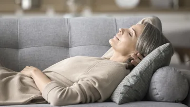 Top 4 Restful Sleep Strategies Tailored for the 50+ Body  2 A 50+ woman napping on the couch, illustrating the importance of rest in healthy aging.