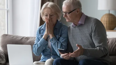 Think You’d Never Fall for a Scam? Think Again! 1 A shocked older couple is staring at a laptop, reacting to the possibility of fraud, financial loss, or online scams.