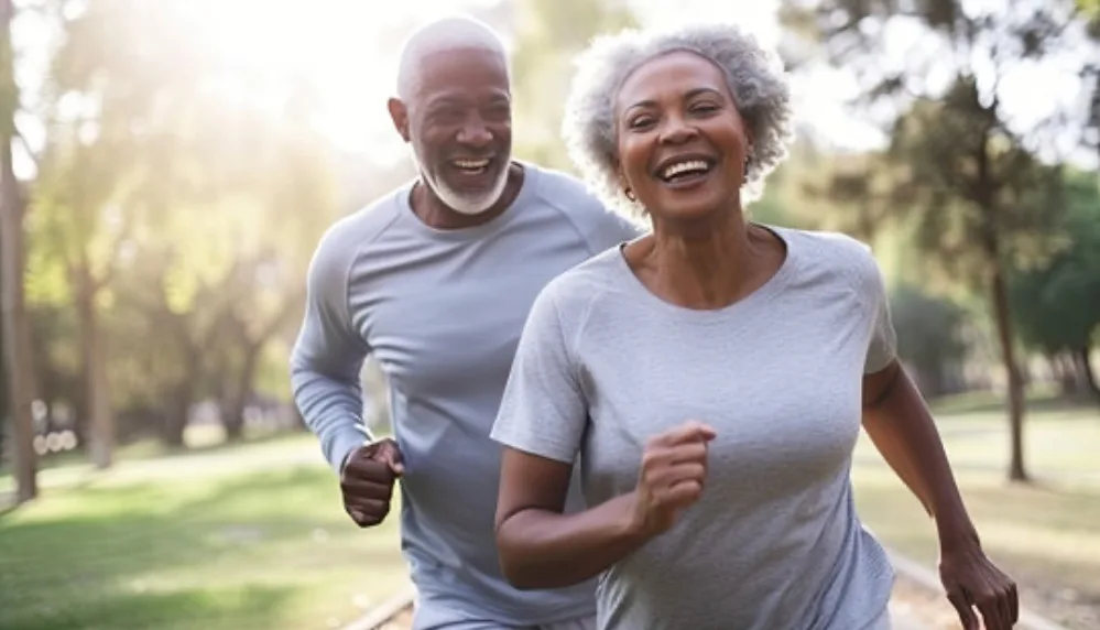 How to Boost Your Vitamin D Levels Naturally—All Year Long 4 Older African American couple running outdoors with soft sunlight in the background, symbolizing active aging and vitamin D awareness.