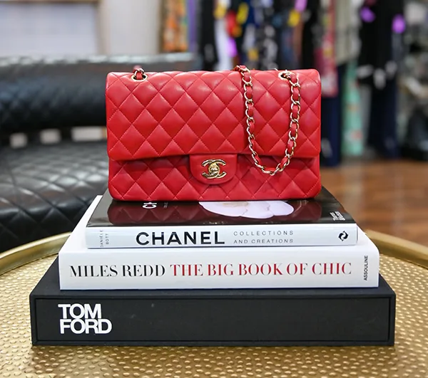 Clotheshorse Anonymous 4 A red Chanel handbag is styled atop iconic fashion books at Clotheshorse Anonymous, a Dallas consignment boutique for pre-owned luxury finds.