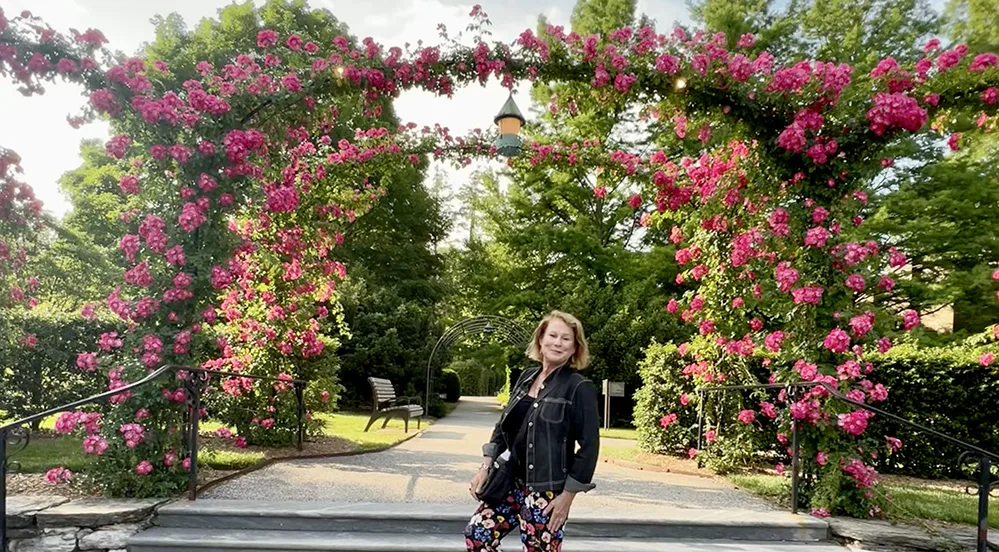 Explore Brandywine Valley: Gardens, Art, Covered Bridges & History 3 Sharon Kurtz, the author, under the rose-covered arch at Longwood Gardens in Brandywine Valley, a top garden travel destination in Pennsylvania.