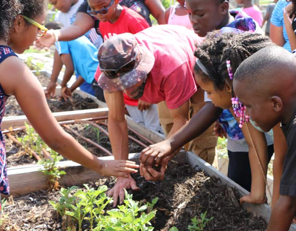 How Your Visit to the State Fair of Texas Benefits Communities 5 Children planting in community garden beds as part of Big Tex Urban Farms educational program