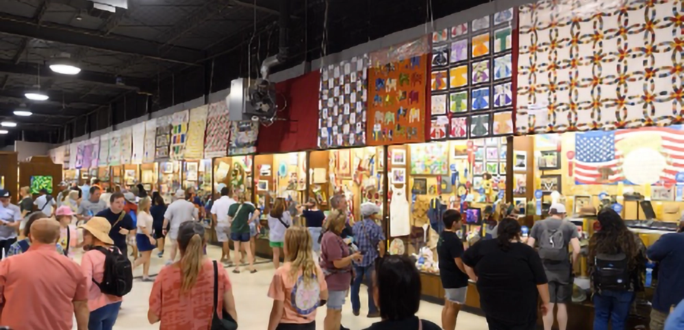 State Fair of Texas 2025 8 Crowds of visitors browsing colorful quilts and crafts displays in the Creative Arts Building at the State Fair of Texas, with hundreds of handmade items on exhibition walls