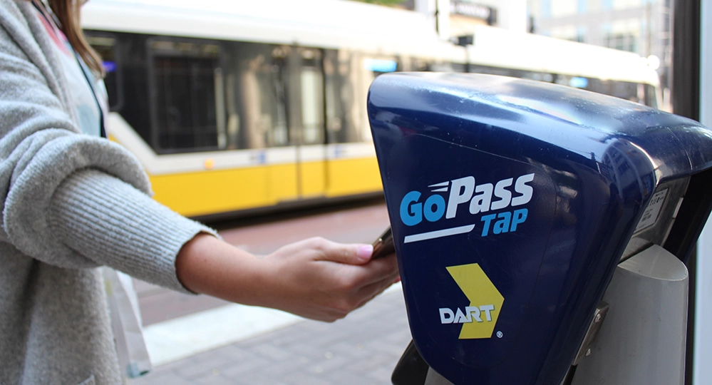 Big Texas and DART 3 Woman using GoPass Tap card to pay for DART fare at station fare payment card reader