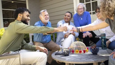 The Circle That Sustains Us: How connection supports healthy aging 17 Five diverse adults of different ages raising cups in a toast together on an outdoor patio, representing intergenerational friendship and community support