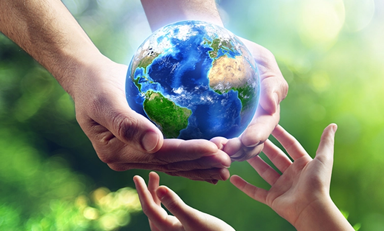 Living Greener for your Grandchildren 1 Older hands carefully passing the Earth globe to younger hands reaching up to receive it, representing environmental legacy and intergenerational responsibility for the planet.