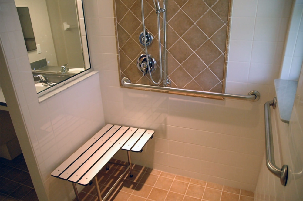How to Create a Comfortable Home for Multigenerational Living 2 Accessible bathroom with grab bars and shower bench for safe multigenerational home living and elderly mobility support.