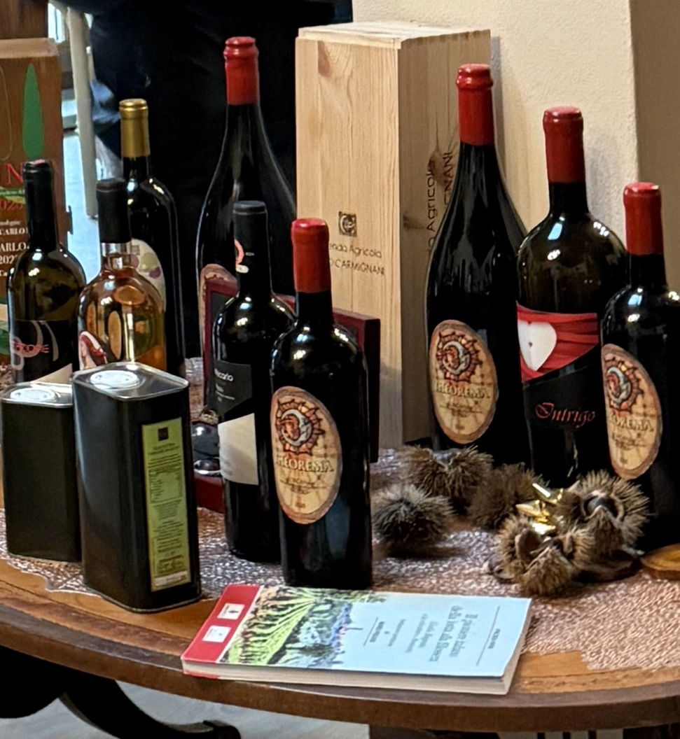 3 Hidden Culinary Gems in Tuscany 2 Assortment of wines and olive oils on a wooden table at Azienda Agricola Carmignani.