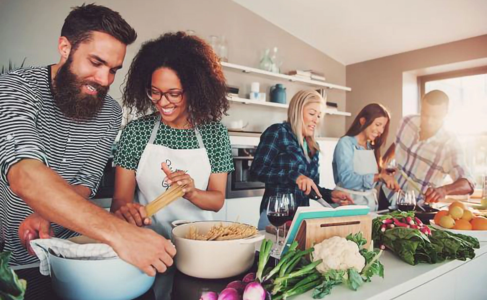 5 Thoughtful Wedding Gift Ideas That Go Beyond the Usual 3 Diverse group of friends enjoying cooking class together as unique wedding gift experience