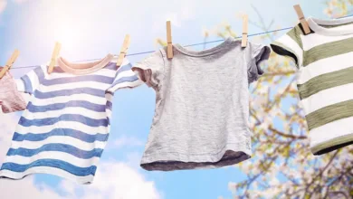 How My Depression-Era Parents Taught Me Sustainable Living 4 Children's clothes hanging on an outdoor clothesline with wooden clothespins against a blue sky and trees, representing sustainable living practices from the Depression era.