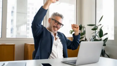 How To Build a Diverse Investment Portfolio in Your 50s 3 Confident businessman in his 50s celebrating success at laptop in modern office