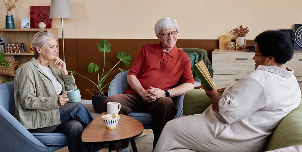 A group of adults gathered for a book club, building meaningful friendships in retirement through shared interests