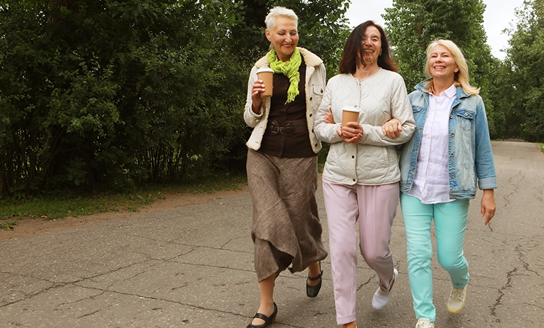 Two friends walking outdoors together, building friendships after 50 through shared activity