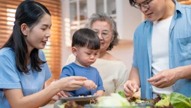 How to Create a Comfortable Home for Multigenerational Living 4 Three generations cooking together in open kitchen of multigenerational home with grandmother parents and child preparing meal