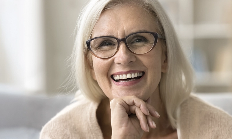 Senior Dental Care 1 Smiling senior woman with glasses showing healthy white teeth, representing successful dental care in golden years