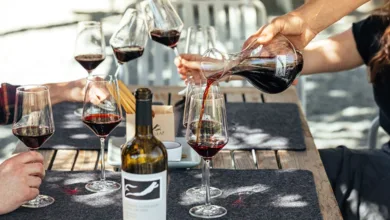 Wine Lovers: Meet the visionaries bringing small wineries together 7 Wine tasting scene with a person pouring red wine from a decanter into glasses, with Frog's Leap wine bottle visible, representing Wine Atlas Collective member winery experience