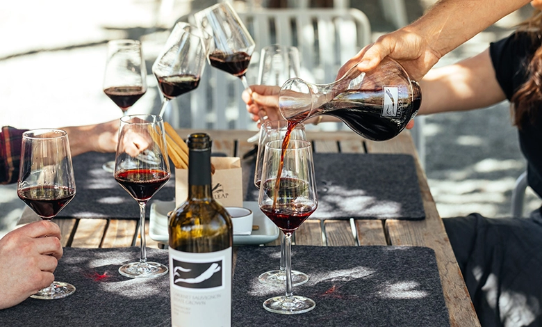 Wine Lovers 1 Wine tasting scene with a person pouring red wine from a decanter into glasses, with Frog's Leap wine bottle visible, representing Wine Atlas Collective member winery experience