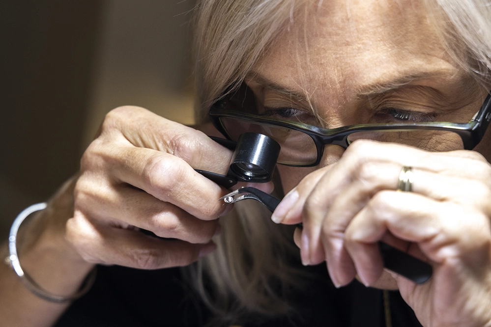 Turning Passion Into Purpose After 50: 3 creatives living their dream 4 Denise Fletcher polishing handmade jewelry with grinding wheel showing the hands-on metalwork skills of DEDA Designs