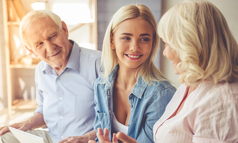 Multi-generational family smiling together discussing estate planning with adult daughter and elderly parents showing positive family communication