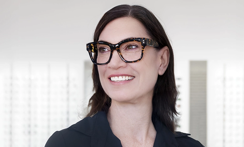 A poised woman wearing tortoiseshell Mensa eyeglass frames, reflecting smart and confident style.