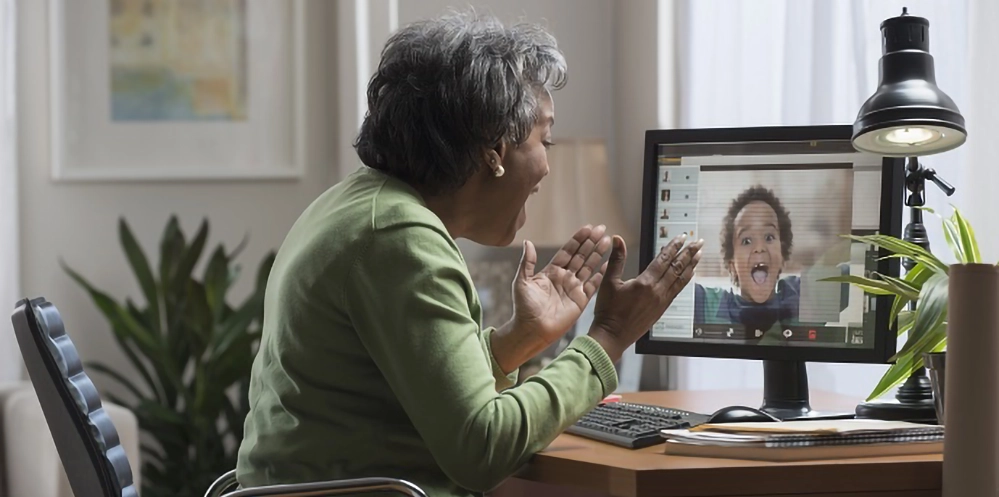 Senior Black woman on video call using computer staying connected with family demonstrating technology for older adults