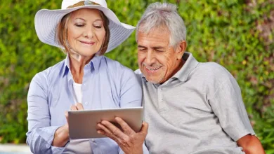 Senior couple outdoors using tablet together learning technology and staying connected