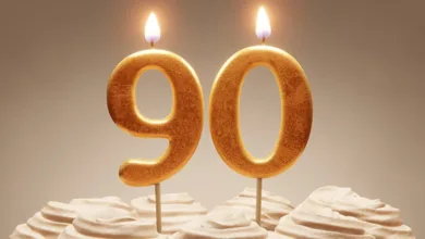 Golden number candles forming “90” atop a frosted cake, symbolizing Social Security’s 90th anniversary celebration.