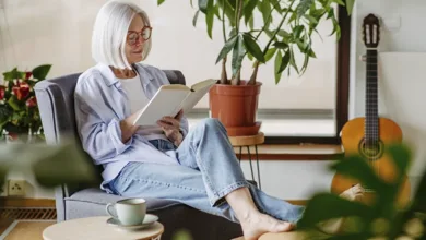 Woman over 50 reading a book at home staying curious for healthy aging well after 50 lifestyle.