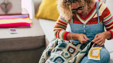 Woman crocheting colorful granny square blanket showing mindful craft and creative expression with vibrant yarn