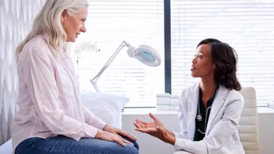 Mature woman consulting with female doctor in medical office about bladder health and urinary concerns after 50