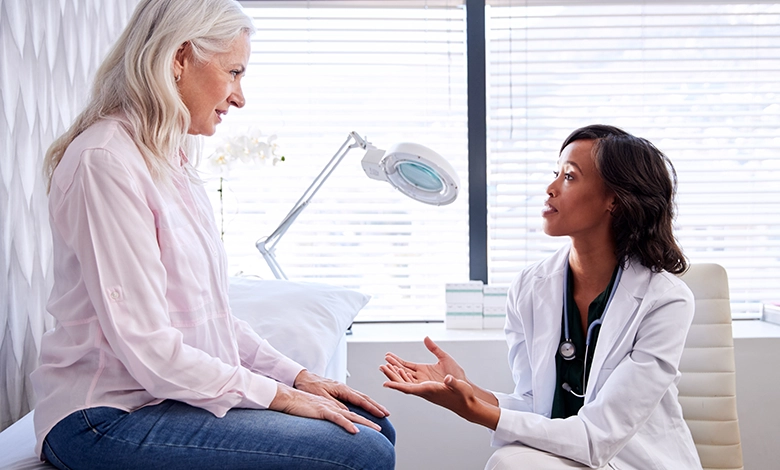 Mature woman consulting with female doctor in medical office about bladder health and urinary concerns after 50