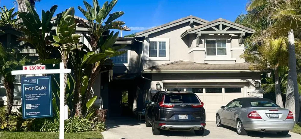 House with cars in the driveway and a for sale sign on the lawn House with cars in the driveway and a for sale sign on the lawn