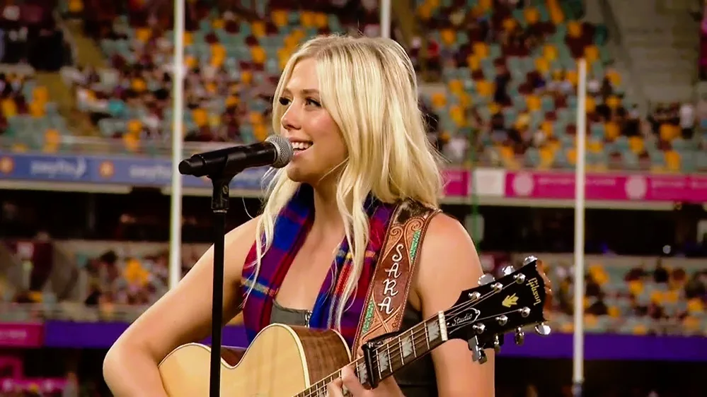 Sara Berki performing Take Me Home Country Roads at an Australian Football League match 54 years after John Denver first sang it the song public Sara Berki performing Take Me Home Country Roads at an Australian Football League match 54 years after John Denver first sang it the song public
