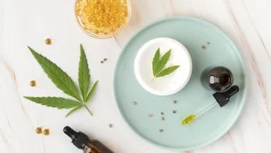How to Choose Your First CBD Product: A Beginner's Guide 3 Flat lay of CBD tincture bottles, golden capsules, and hemp leaves on marble surface