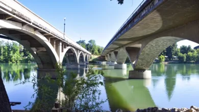 Historic Diestelhorst Bridge with curved arches beside modern Lake Redding Bridge spanning Sacramento River in Redding California