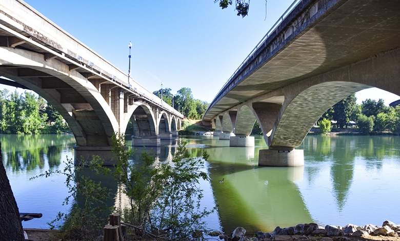 Historic Diestelhorst Bridge with curved arches beside modern Lake Redding Bridge spanning Sacramento River in Redding California