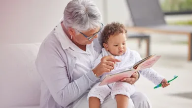 9 Proven Ways to Create a Love of Reading from Infancy 1 Grandmother reading book to infant grandbaby on lap demonstrating early reading from infancy and bonding
