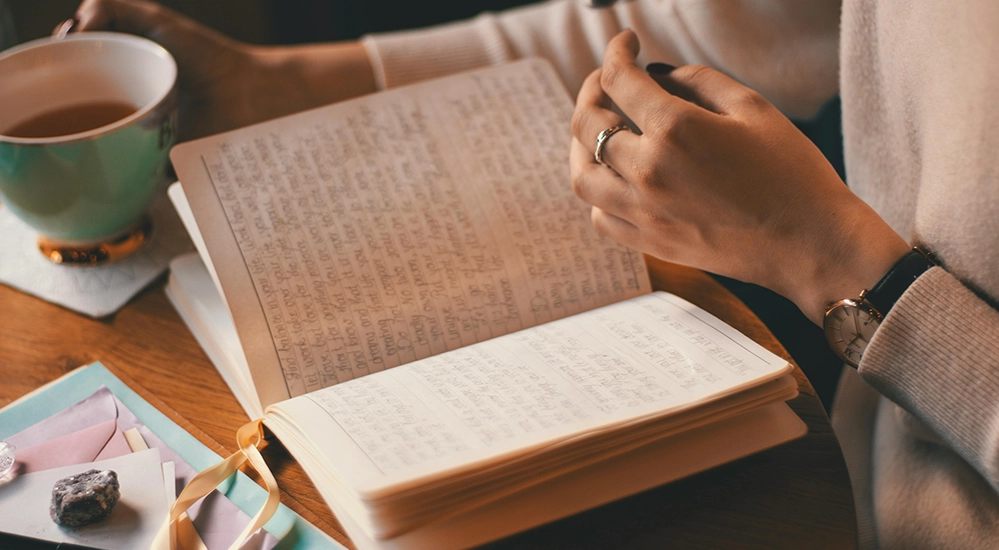 Woman journaling with tea as part of a self-care routine