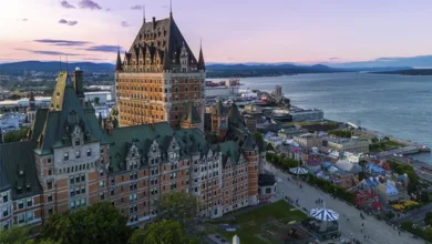 Aerial view of Fairmont Le Château Frontenac overlooking the St. Lawrence River and Old Québec City at sunset.