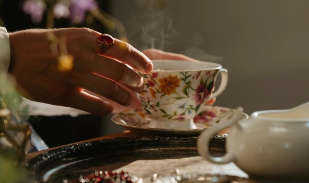 Hand reaching for a steaming cup of tea as a simple self-care ritual