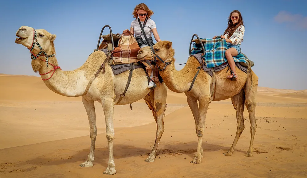 Stay Well While You Wander 4 women riding camels W