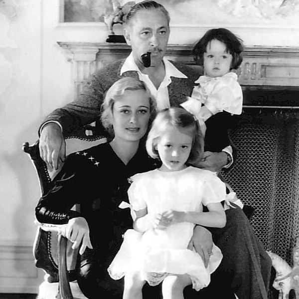 Dolores Costello seated holding daughter Dolores on her lap, with John Barrymore standing behind holding son John Drew Barrymore, family portrait 1934