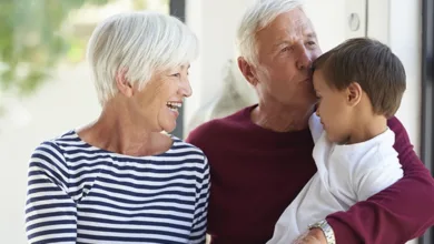 Science Says Babysitting Your Grandkids Is Good for Your Brain 19 Grandparents smiling with young grandson — babysitting your grandkids is linked to better brain health