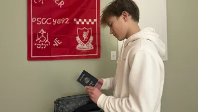 Grandson holding passport and packing for first trip abroad