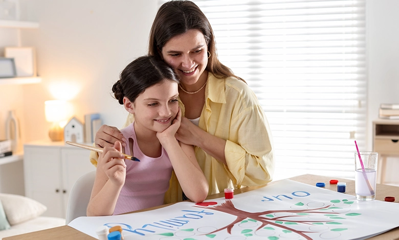 Mother and daughter painting a family tree together at home